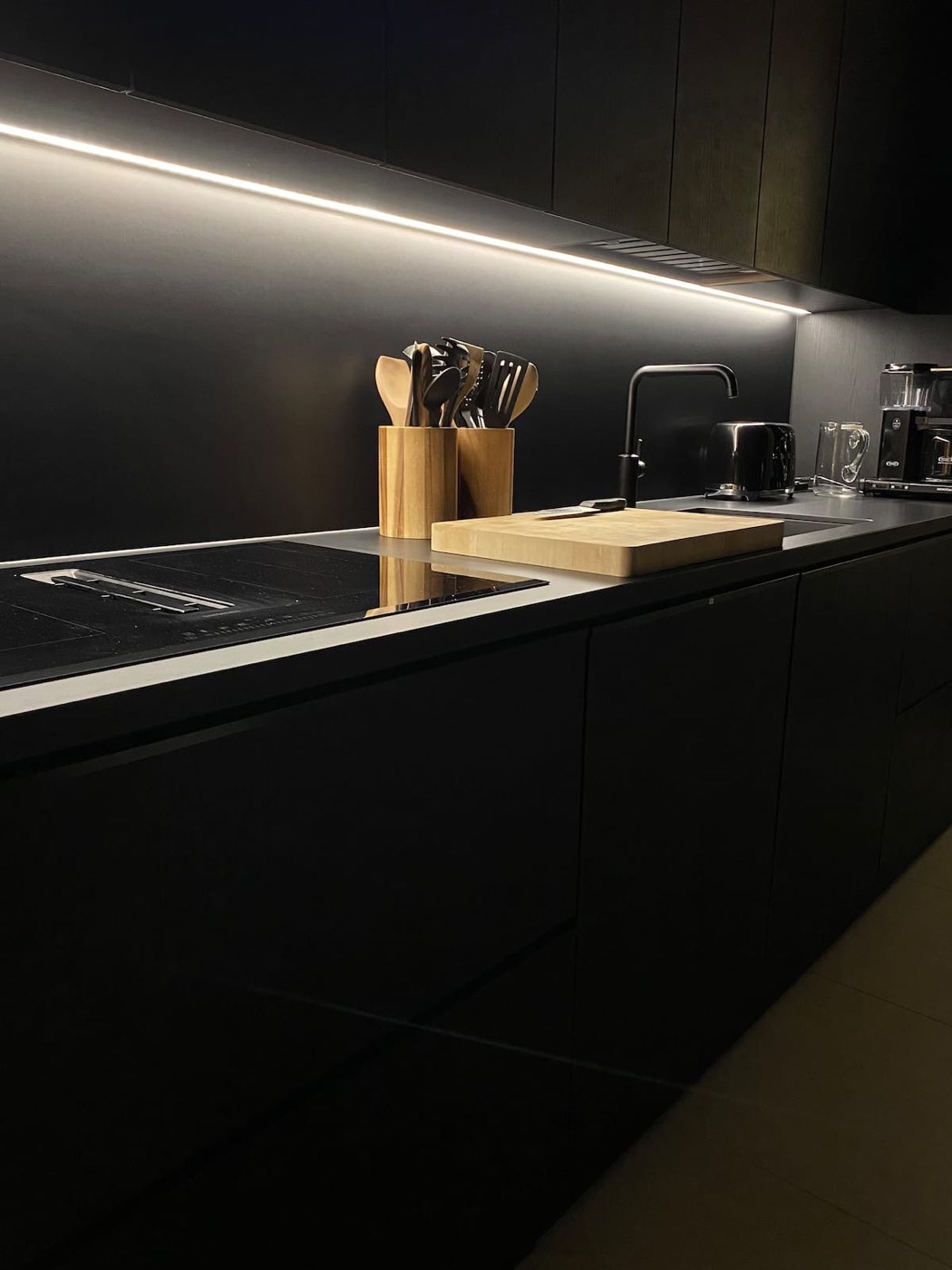 Black kitchen with long worktop and under-cabinet lighting