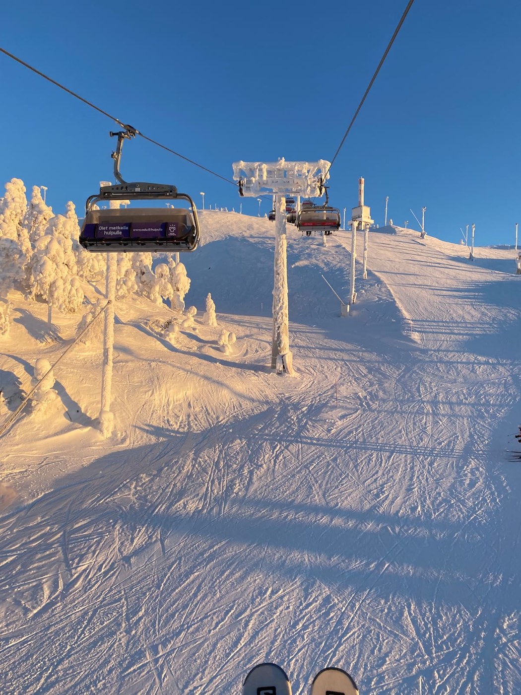 Chairlift above a sunny groomed slope